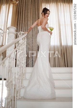 a Beautiful and happy bride on a large beautiful staircase. a Beautiful and happy bride on a large beautiful staircase. 131907282