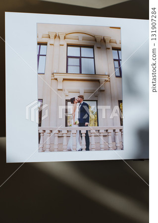 page of an open photo book with wedding photos on a white table 131907284