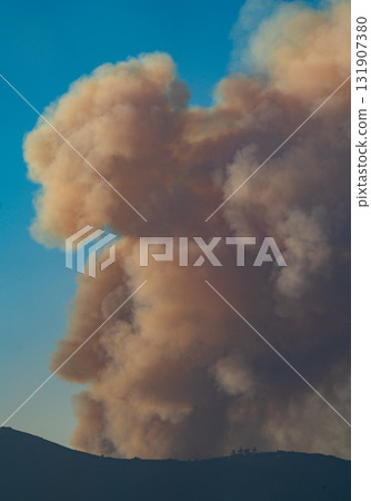 Massive Smoke Plumes Rise Against Clear Blue Sky 131907380