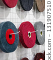 Various colorful felt circles displayed on a wire grid for polishing 131907510