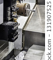 CNC machine in operation with metal shavings during precision machining process in a workshop 131907525