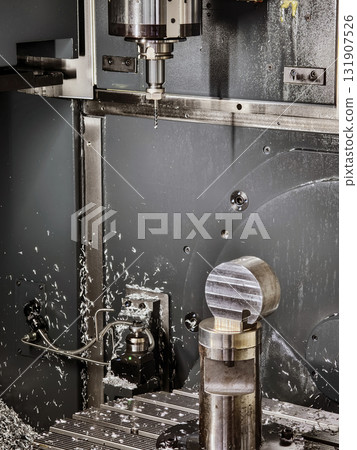 Machining process in an industrial workshop with a CNC machine cutting metal part 131907526