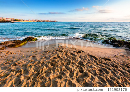 sunrise on a sandy town beach in mellow season. beautiful and warm weather on the shores of black sea. sozopol coast in morning light sunrise on a sandy town beach in mellow season. beautiful and warm weather on the shores of black sea. sozopol coast in morning light 131908176