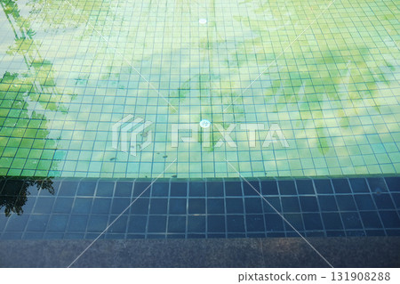 Nature reflected on the water surface and visible on the tiles of the swimming pool background 131908288