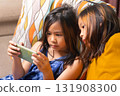 Two Asian Girls Watching Smartphone Screen Together at Home 131908300