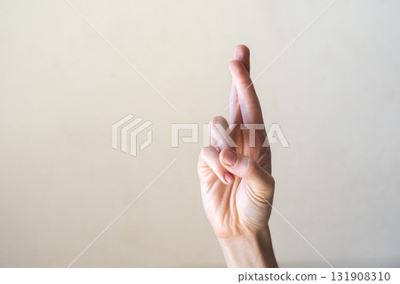 A hand with a light skin tone is raised, showing the number one with the index finger extended. The background is a neutral color, emphasizing the gesture. 131908310