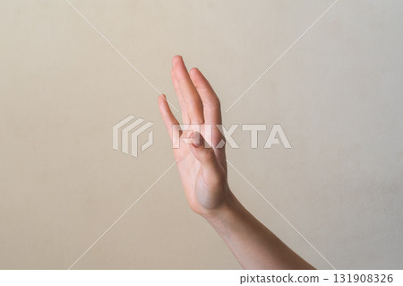 A close-up of a human hand with fingers extended, palm facing forward. The hand is light-skinned with visible details of the fingers and palm. 131908326