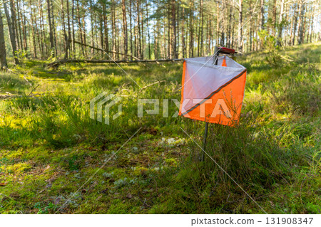 A prism marker and electronic composter at an orienteering control point 131908347