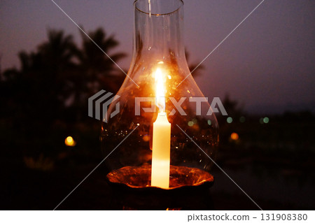 Close up beautiful candle light in glass bottle in dark and dusk evening and night scene Close up beautiful candle light in glass bottle in dark and dusk evening and night scene 131908380