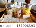 Various uncooked cereals with muesli and corn flake in glass jar on table 131908393