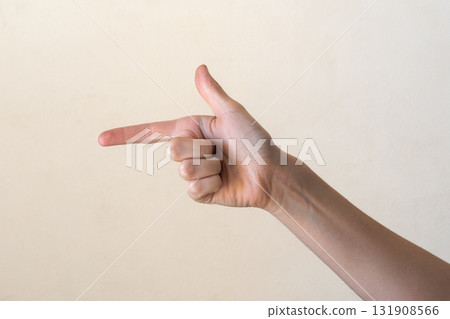 A human hand making a finger gun gesture against a neutral background. The hand is Caucasian with visible veins and a light skin tone. A human hand making a finger gun gesture against a neutral background. The hand is Caucasian with visible veins and a light skin tone. 131908566