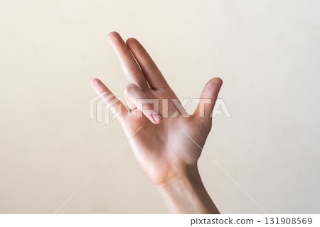 A close-up of a human hand displaying the Pataka Tripitaka mudra. The hand is positioned with fingers extended and separated, symbolizing the transmission of teachings. A close-up of a human hand displaying the Pataka Tripitaka mudra. The hand is positioned with fingers extended and separated, symbolizing the transmission of teachings. 131908569