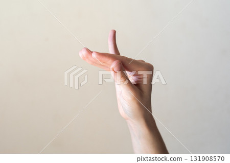 A close-up of a human hand displaying the Hamsapaksha mudra. The hand is positioned with fingers extended and separated, symbolizing the transmission of teachings. A close-up of a human hand displaying the Hamsapaksha mudra. The hand is positioned with fingers extended and separated, symbolizing the transmission of teachings. 131908570