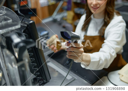 A woman is actively using a barcode scanner in a retail store 131908898