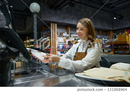 A woman cashier at a store counter is scanning an item A woman cashier at a store counter is scanning an item 131908904