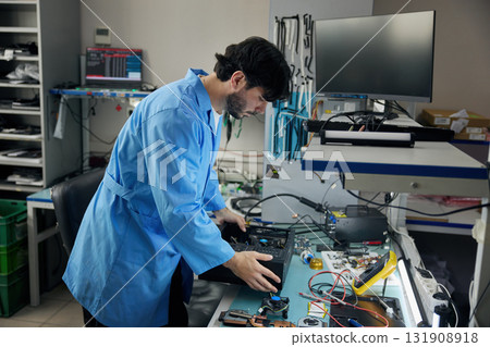 Portrait of a man soldering technician, wearing a pair of protective goggles in a lab 131908918