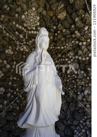 Sculpture of a Bodhisattva and wall covered with seashell patterns in Chua Tu Van Pagoda Sculpture of a Bodhisattva and wall covered with seashell patterns in Chua Tu Van Pagoda 131908924
