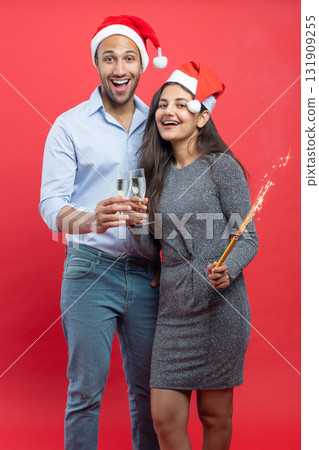 Smiling family in sparkling tinsel celebrating Christmas eve with wine glass and sparkling Smiling family in sparkling tinsel celebrating Christmas eve with wine glass and sparkling 131909255