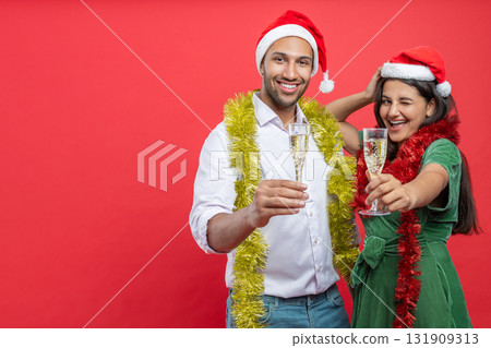 Festive couple with champagne glasses in hands sharing toast for Christmas Festive couple with champagne glasses in hands sharing toast for Christmas 131909313