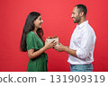 Romantic young couple standing close together woman receives surprise gift box from her boyfriend 131909319
