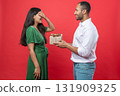 Romantic young couple standing close together woman receives surprise gift box from her boyfriend 131909325