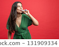 Beautiful woman celebrating her Christmas holding noisemaker 131909334