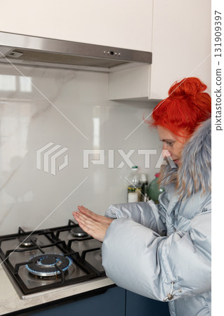Woman Warming Hands Over Gas Stove in Winter to Save Energy Woman Warming Hands Over Gas Stove in Winter to Save Energy 131909397