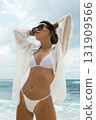 Beautiful young woman in bikini on beach 131909566