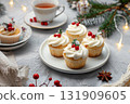 Festive Cupcakes topped with icing and holly decorations, spruce branch and cranberries. Image for cafe menu, Banner. Christmas iced little cakes. Joyous holiday celebrations and gatherings. Cup cakes 131909605