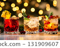 Festive Holiday Cocktails. Glasses of cocktails with Christmas decoration on bokeh lights background. Season drink set. Vibrant colorful display of various winter cocktails for New Year celebrations 131909607