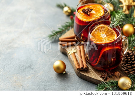 Hot red mulled wine with christmas spices, orange slice, anise and cinnamon sticks. Two glasses of mulled wine on white table with red checkered napkin with spices and fruits. Traditional Autumn drink 131909618