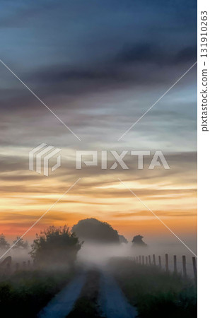 A Serene Sunrise Over a Misty Road Landscape That Inspires Tranquility and Exploration 131910263