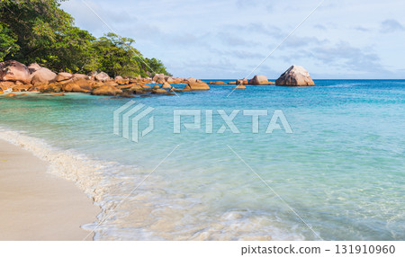 Vibrant tropical beach scene with turquoise water, gentle waves and white sand 131910960