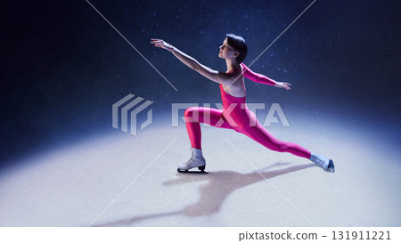 Woman ice skater in pink costume extending arms in graceful balance under blue spotlight 131911221