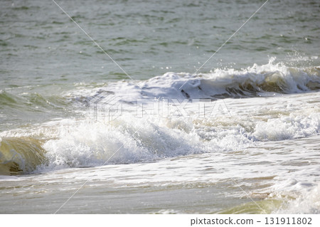 The Waves are Gently Lapping at the Shoreline beneath a Beautiful, Calm Sky Above 131911802