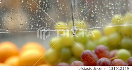 Fresh organic fruits displayed at a market, seen through a clear umbrella with raindrops 131912129