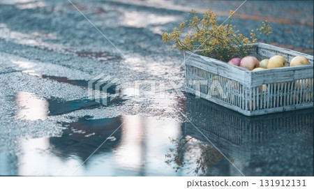 Freshly picked fruits lie abandoned in a wooden basket on the rain-soaked street 131912131