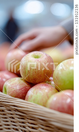 Ripe organic apples displayed in a tall basket, showcasing freshness and eco-friendly farming practices 131912136