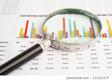 Magnifying glass on data business graphs paper. 131912577