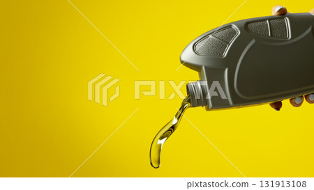 Close up of gray oil bottle pouring transparent motor fluid on bright yellow background Close up of gray oil bottle pouring transparent motor fluid on bright yellow background 131913108