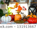Decor of white classic kitchen with pumpkins, garlands, autumn bouquet with yellow leaves for Halloween and harvest. Autumn mood in home interior, modern loft style. real estate, insurance, mortgage 131913667