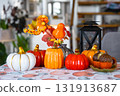 Decor of white classic kitchen with pumpkins, garlands, autumn bouquet with yellow leaves for Halloween and harvest. Autumn mood in home interior, modern loft style. real estate, insurance, mortgage 131913687