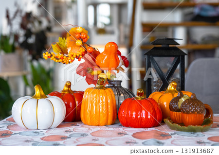 Decor of white classic kitchen with pumpkins, garlands, autumn bouquet with yellow leaves for Halloween and harvest. Autumn mood in home interior, modern loft style. real estate, insurance, mortgage Decor of white classic kitchen with pumpkins, garlands, autumn bouquet with yellow leaves for Halloween and harvest. Autumn mood in home interior, modern loft style. real estate, insurance, mortgage 131913687