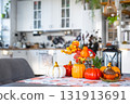 Decor of white classic kitchen with pumpkins, garlands, autumn bouquet with yellow leaves for Halloween and harvest. Autumn mood in home interior, modern loft style. real estate, insurance, mortgage 131913691