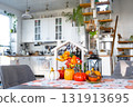 Cozy autumn decor on white kitchen with tiny house and keys, pumpkins, autumn leaves, autumn mood, Halloween, Harvest Festival, housing, relocation, mortgage, insurance. 131913695