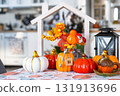 Cozy autumn decor on white kitchen with tiny house and keys, pumpkins, autumn leaves, autumn mood, Halloween, Harvest Festival, housing, relocation, mortgage, insurance. 131913696