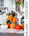 Cozy autumn decor on white kitchen with tiny house and keys, pumpkins, autumn leaves, autumn mood, Halloween, Harvest Festival, housing, relocation, mortgage, insurance. 131913697