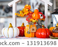 Cozy autumn decor on white kitchen with tiny house and keys, pumpkins, autumn leaves, autumn mood, Halloween, Harvest Festival, housing, relocation, mortgage, insurance. 131913698