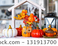 Cozy autumn decor on white kitchen with tiny house and keys, pumpkins, autumn leaves, autumn mood, Halloween, Harvest Festival, housing, relocation, mortgage, insurance. 131913700