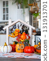 Cozy autumn decor on white kitchen with tiny house and keys, pumpkins, autumn leaves, autumn mood, Halloween, Harvest Festival, housing, relocation, mortgage, insurance. 131913701